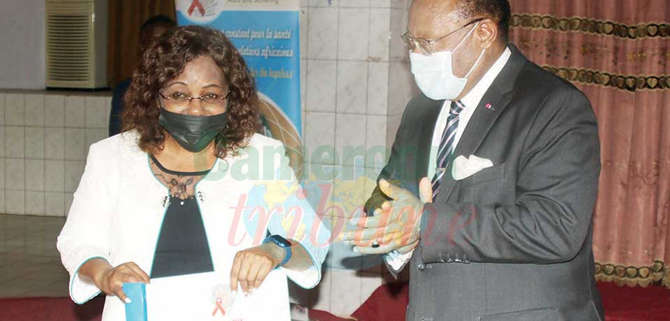Jean Stephané Biatcha hands BUM teaching materials to the Minister of Secondary Education in the presence of several dignitaries.