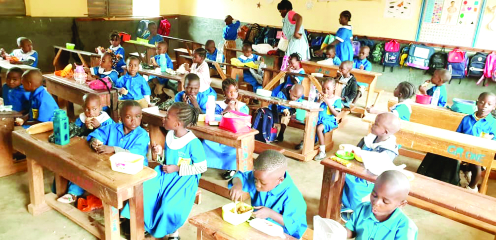 Pupils enjoying lunch from their classroom desk.