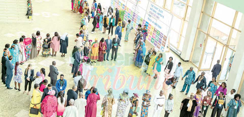 Women standing in a circle, forming the Cameroon map, reflective of unity.