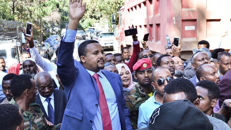Jawar Mohamed (costume et main levée), l’un des bénéficiaires du geste d’Abiy Ahmed.
